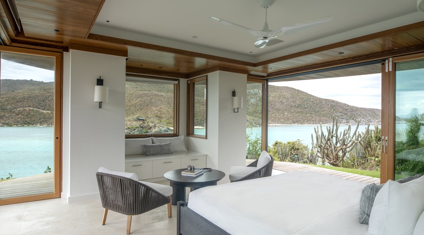 Wake up to panoramic water views from your luxurious bedroom, where floor-to-ceiling windows frame the serene landscape beyond.