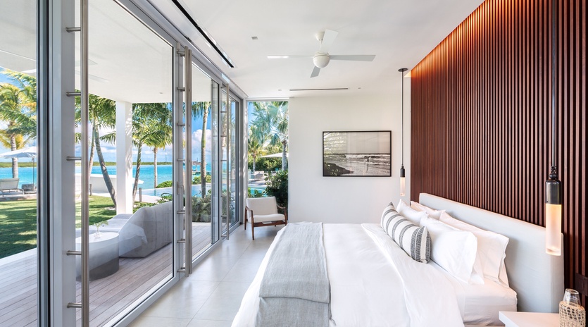 Wake up to stunning sea views through floor-to-ceiling windows, where tropical palms frame your private beachfront paradise.