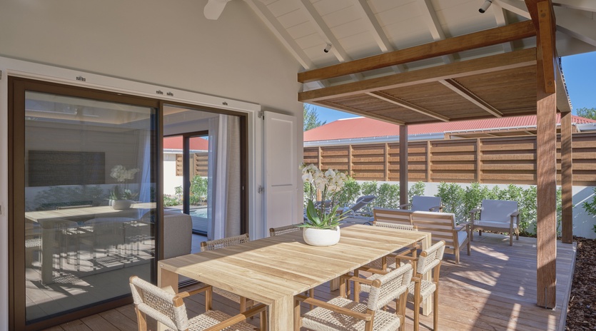 Relax on your private covered terrace with natural wood dining table and comfortable seating, perfect for enjoying morning coffee or evening meals.