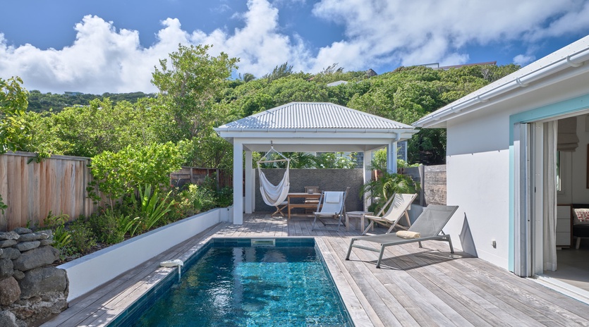 Dive into your private pool paradise, where sun loungers and a hammock await beneath tropical skies for pure relaxation.