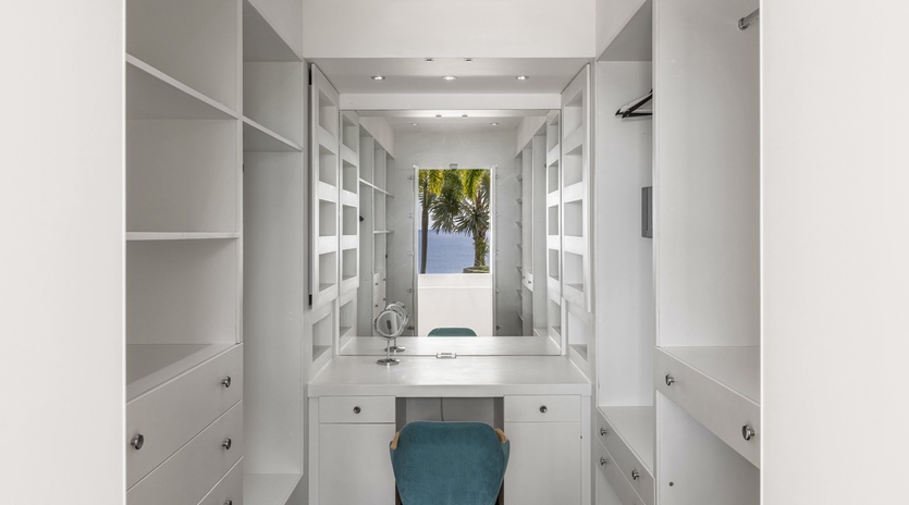 Your private dressing room features floor-to-ceiling storage and a vanity area where you'll start each morning in luxury.
