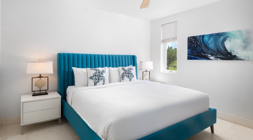 Drift off in your ocean-inspired bedroom, where the stunning teal headboard and wave artwork create a serene coastal retreat.
