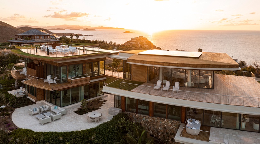 Stunning contemporary property with multi-level terraces overlooking pristine coastline, featuring modern architecture and breathtaking sunset views.