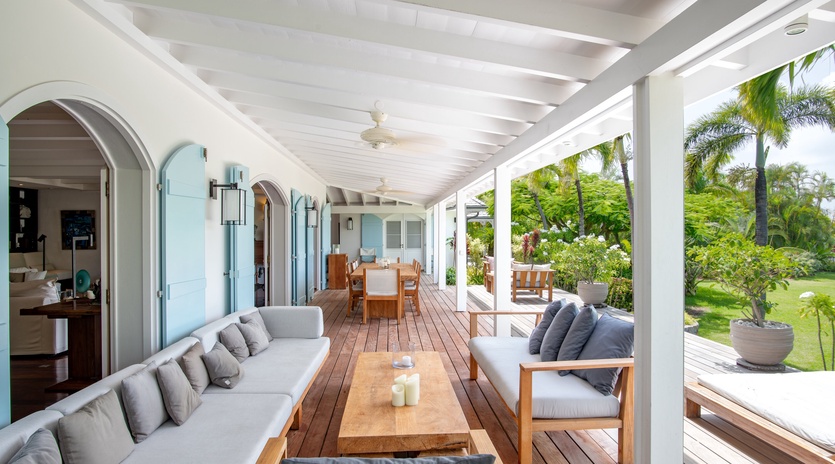 Your expansive covered terrace blends indoor comfort with tropical breezes, featuring plush seating and dining areas perfect for island relaxation.
