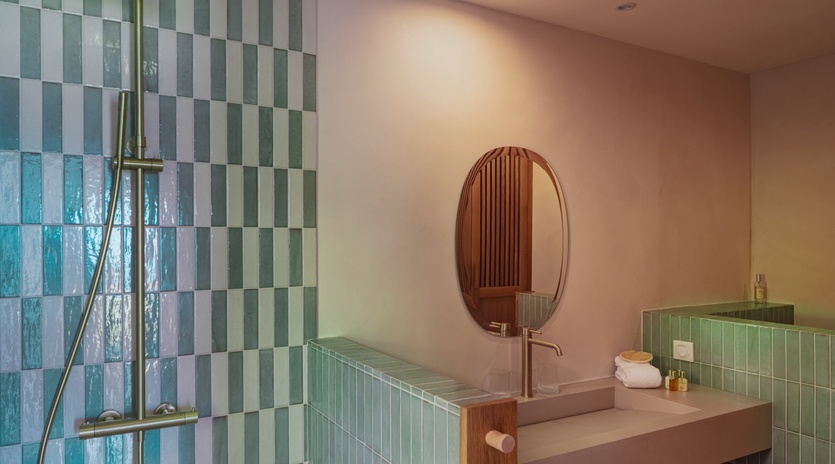 Step into your modern sanctuary featuring glossy seafoam tiles, sleek fixtures, and a warm glow that turns every refresh into a moment of pure relaxation.