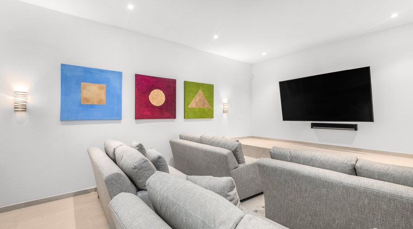 Sink into plush gray sectionals in your private theater room, where colorful artwork and surround sound create the perfect movie night experience.