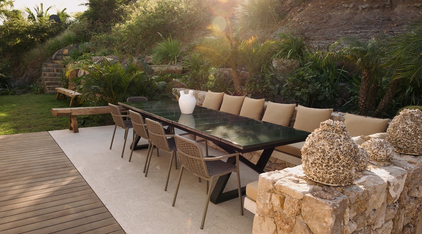 Unwind in your private outdoor sanctuary where tropical palms frame golden sunsets over elegant dining and lounging spaces.