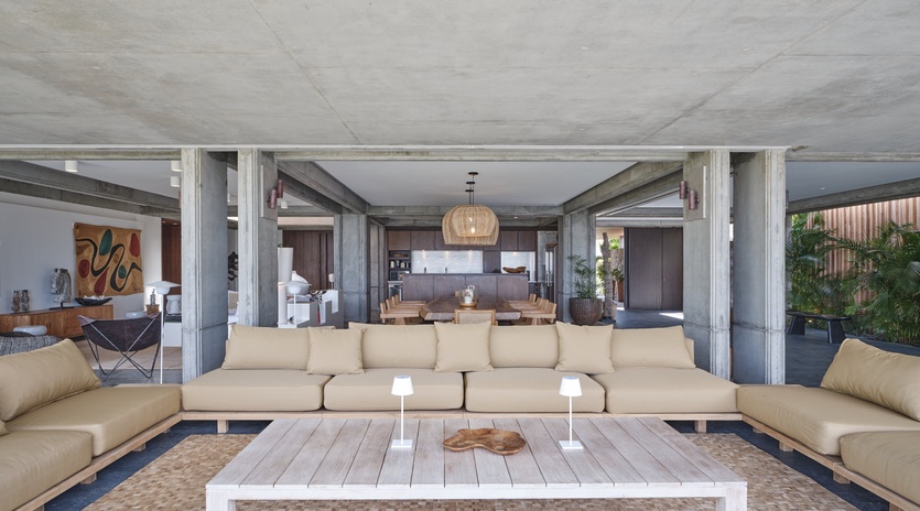 Settle into your spacious living area where concrete beams and warm wood create modern sophistication for memorable gatherings.
