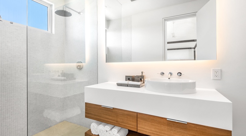 Your sleek bathroom features a rainfall shower and modern vanity, creating a spa-like retreat for refreshing mornings.