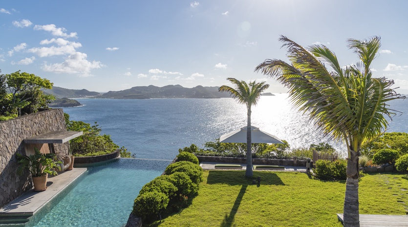 Stunning oceanfront property with infinity pool overlooking pristine waters and tropical islands beyond.