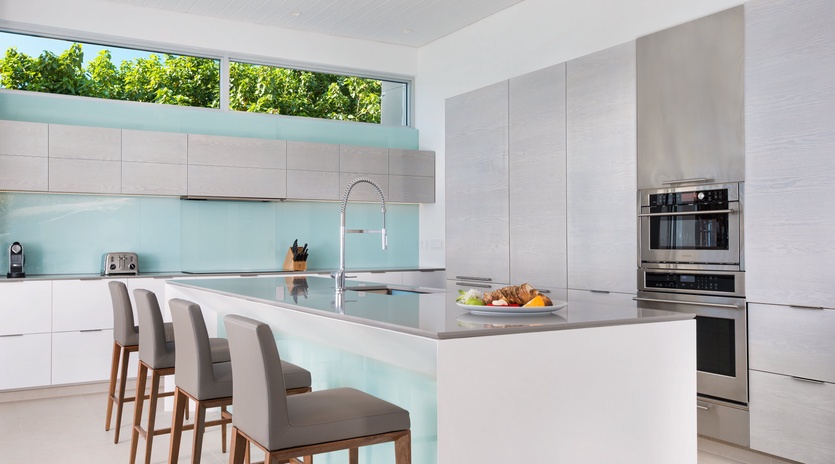 Cook in your sleek, modern kitchen with premium appliances and stunning island views of lush greenery.
