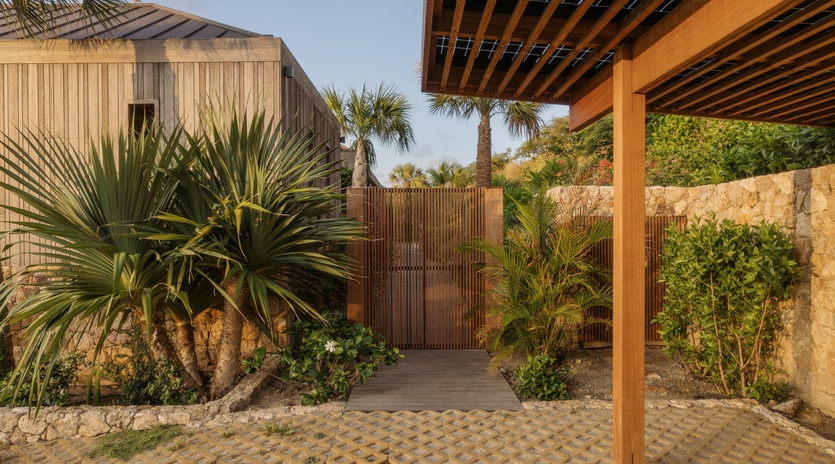 Modern tropical architecture nestled among lush palm gardens and natural stone walls creates a serene island retreat.