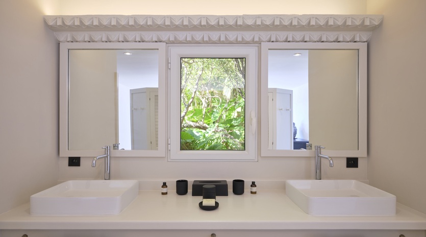 Elegant dual vanity with modern vessel sinks offers you sophisticated comfort, while lush garden views create a serene morning routine.