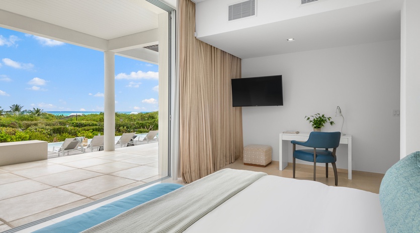 Your serene bedroom opens to stunning ocean views, with crisp linens and modern amenities creating the perfect tropical retreat.
