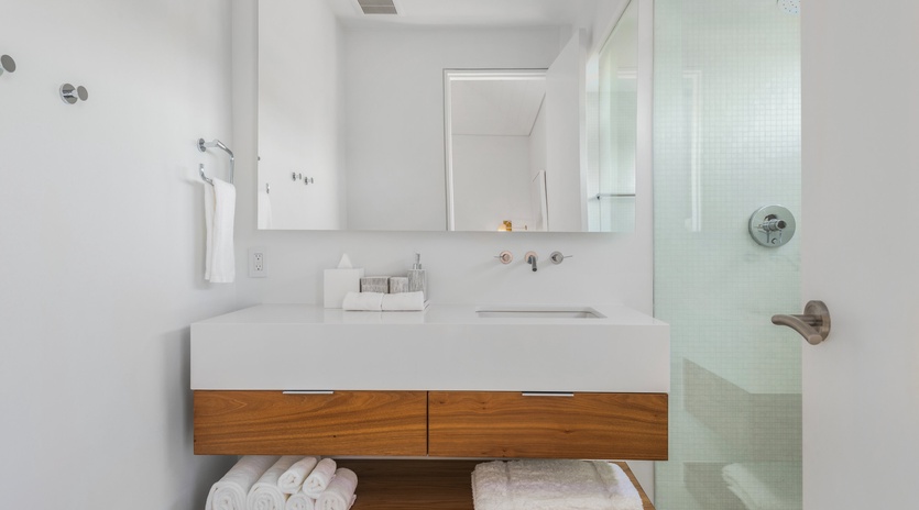 Your modern bathroom features a sleek floating vanity with spa-quality towels and a glass-enclosed shower for your daily refresh.