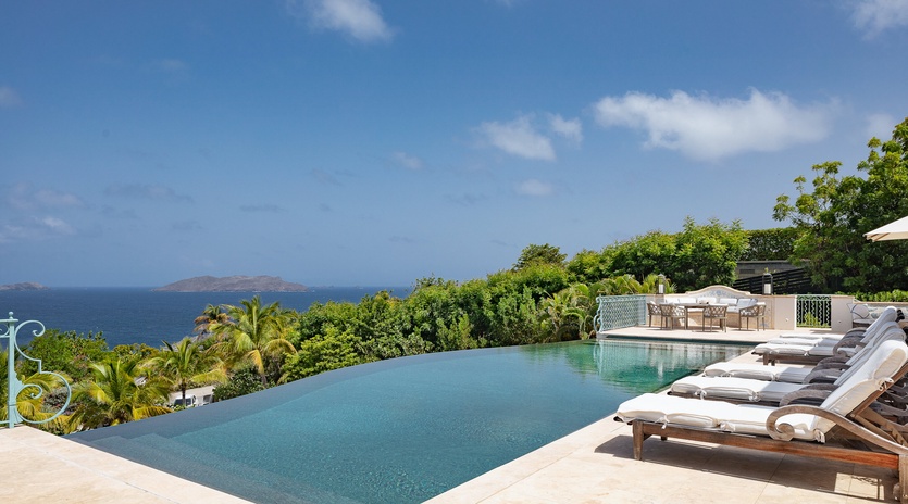 Bask in the infinity pool's serene edge while taking in sweeping ocean views and lush tropical gardens that frame your private paradise.