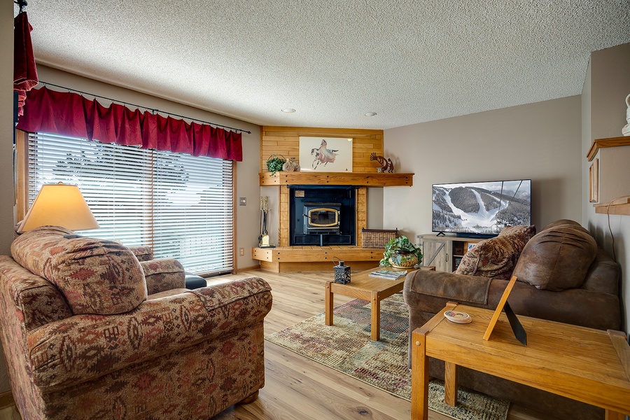 Curl up in this cozy living room where your favorite shows await on a large-screen TV, while the wood fireplace adds mountain charm to your evenings.