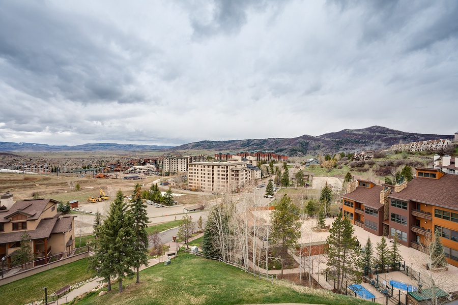 Aerial view of the property nestled in a scenic mountain valley, surrounded by natural landscape and neighboring developments.