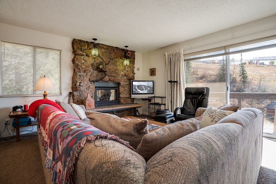 Curl up on plush sofas by the stone fireplace while enjoying your private balcony views of the natural landscape beyond your mountain retreat.