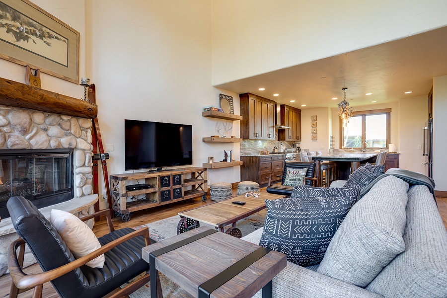 Unwind in this open-concept living space, where a cozy stone fireplace and mountain-inspired décor invite you to relax after a day of adventure. Your perfect retreat awaits.