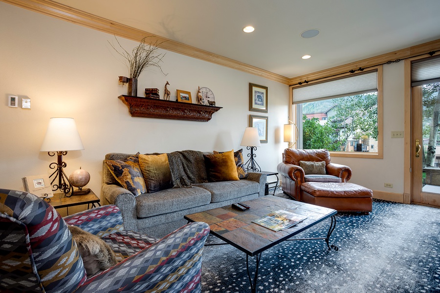 Settle into this inviting living room where natural light pours through large windows, framing peaceful neighborhood views. Sink into plush seating surrounded by warm wood accents and thoughtful decor that makes every moment feel like home.