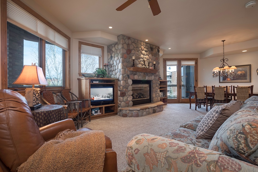 Gather around the river rock fireplace in this inviting living space where plush seating, warm wood accents, and mountain views create your perfect retreat after a day of adventure.