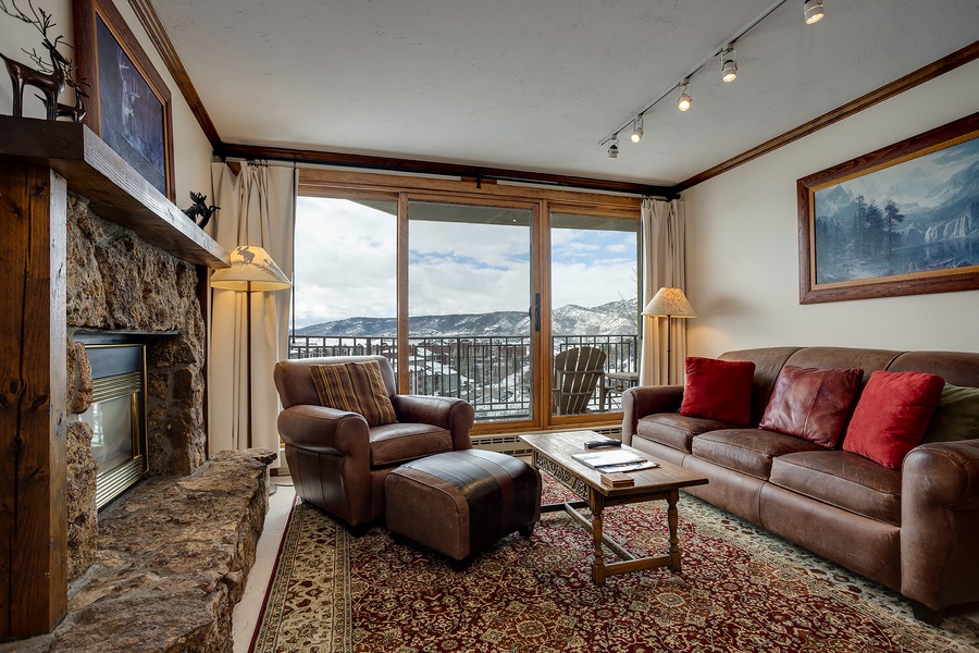 Unwind in your inviting living space, where a cozy stone fireplace and plush leather seating create the perfect retreat. Step out to your private balcony and take in stunning mountain views.