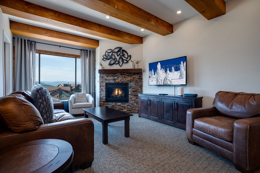 Unwind in your inviting living room where mountain views and a warm fireplace create the perfect retreat. The rustic beamed ceiling and plush seating invite you to relax after a day of adventure.