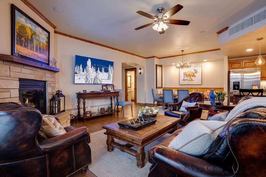 Sink into plush leather sofas by the stone fireplace, where rustic charm meets mountain elegance. Warm wood tones and art-filled walls create your perfect retreat.