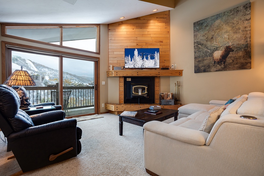 Sink into plush seating by the warm fireplace as you gaze out at stunning mountain views—your perfect retreat after a day of adventure.