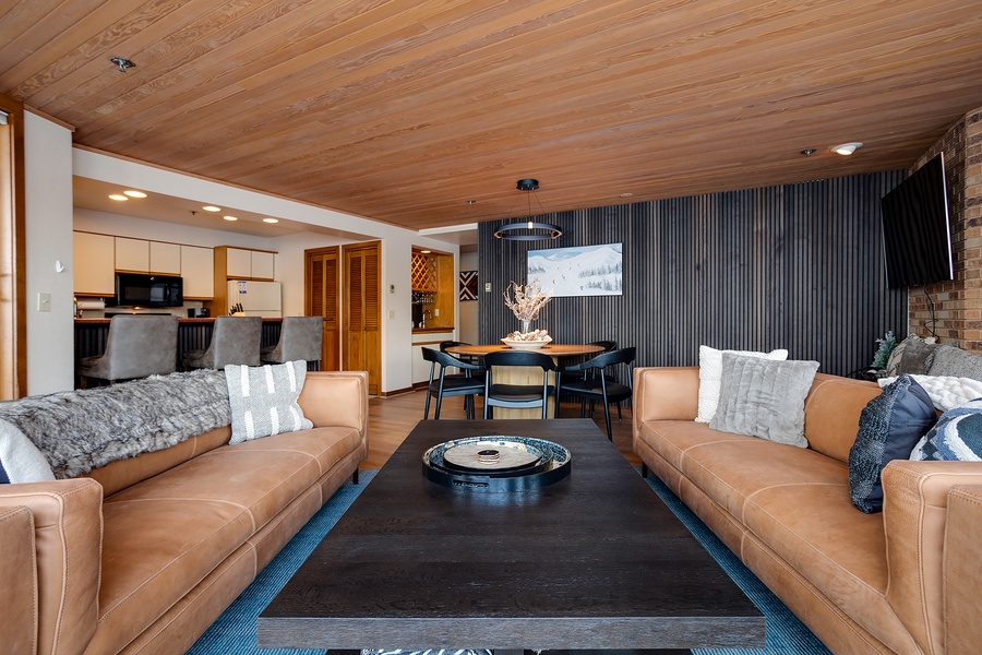 Relax into buttery leather sofas beneath warm wood ceilings, your perfect retreat for cozy evenings after mountain adventures or lakeside explorations.