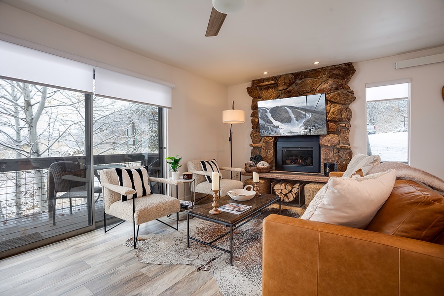 Sink into plush seating by the crackling fireplace as you gaze at snowy peaks through floor-to-ceiling windows—your perfect alpine retreat awaits.