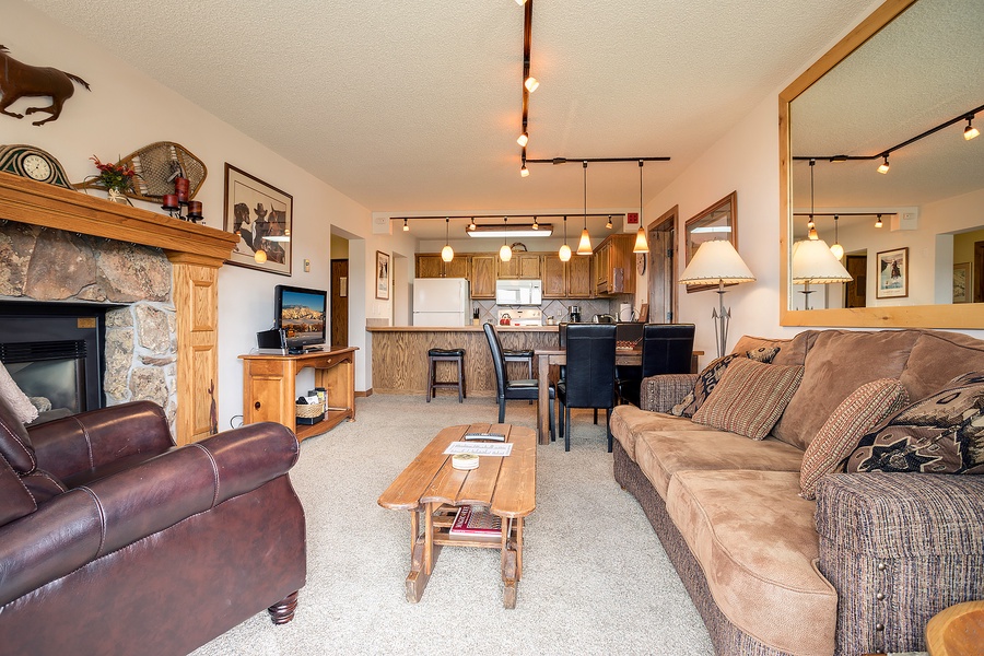 Unwind in your cozy open-concept space where rustic charm meets comfort—plush seating, a warm fireplace, and a fully-equipped kitchen invite you to relax and feel right at home.