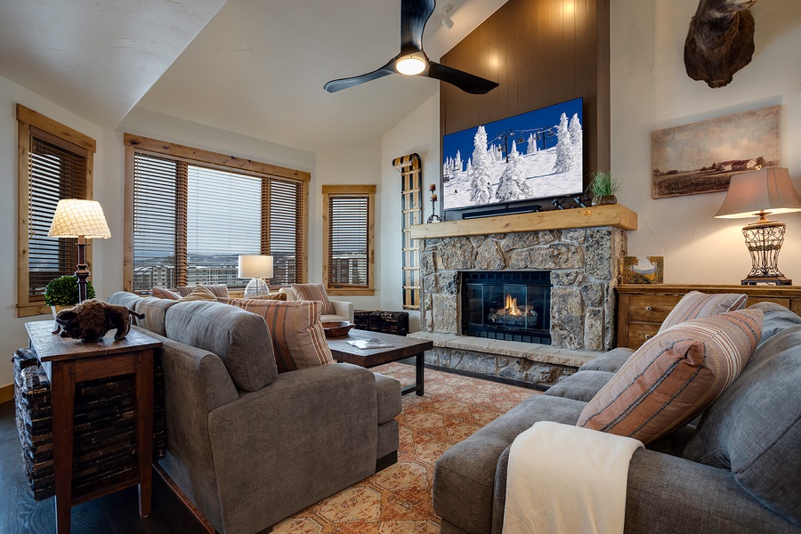 Unwind in your cozy living room with plush seating, a warm fireplace, and mountain views. Vaulted ceilings and rustic décor create a welcoming retreat after a day on the slopes.