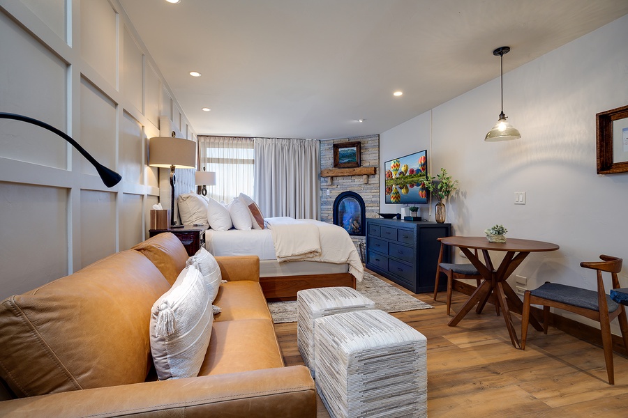 Sink into the plush leather sofa and unwind by your own cozy fireplace, surrounded by thoughtful details—crisp linens, warm wood tones, and charming coastal artwork—all designed for your comfort and relaxation.