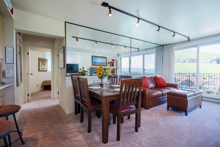 Relax in your open-concept living and dining space, where large windows frame stunning views. The leather sofa invites you to unwind, while the dining table awaits memorable meals together.