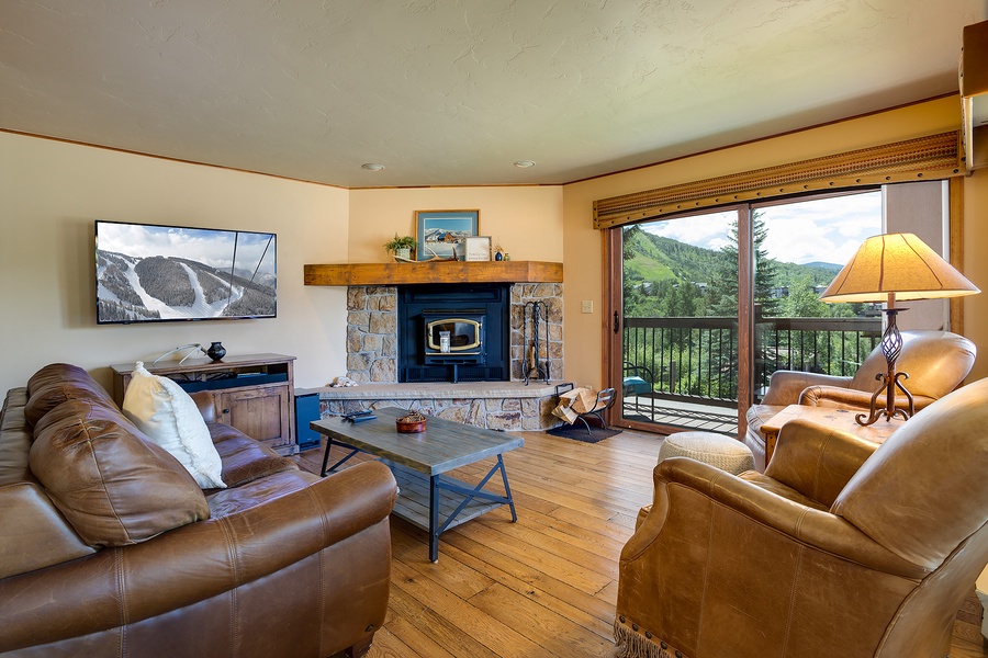 Sink into plush leather seating and enjoy mountain vistas through your private balcony. The cozy fireplace and rustic wood floors create the perfect alpine retreat after your adventures.