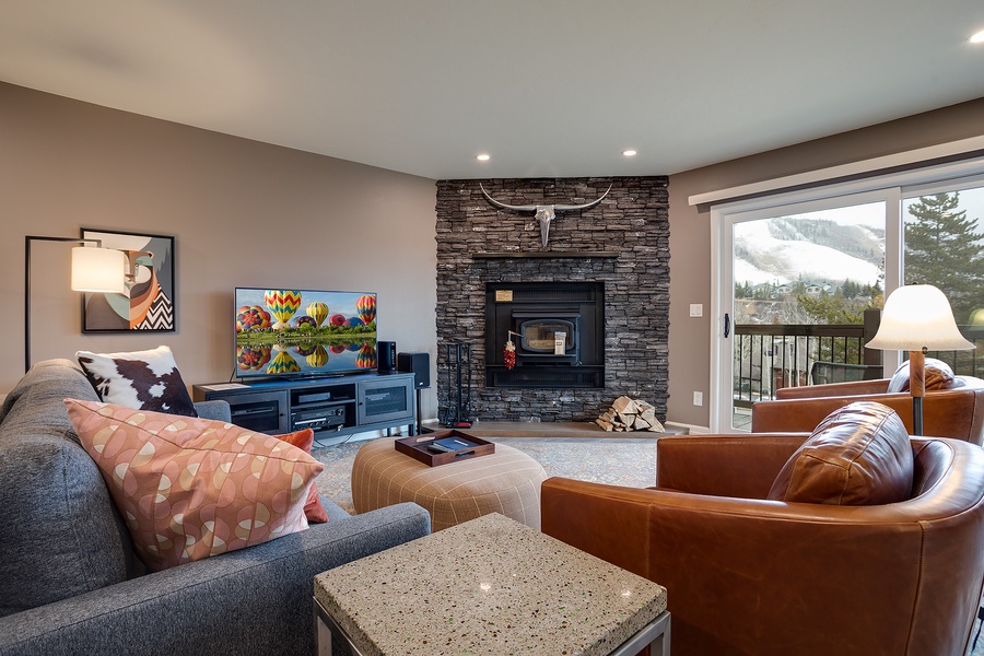Unwind by the stone fireplace as you take in stunning mountain views through the balcony doors. Cozy seating and warm textures make this your perfect retreat after a day exploring.
