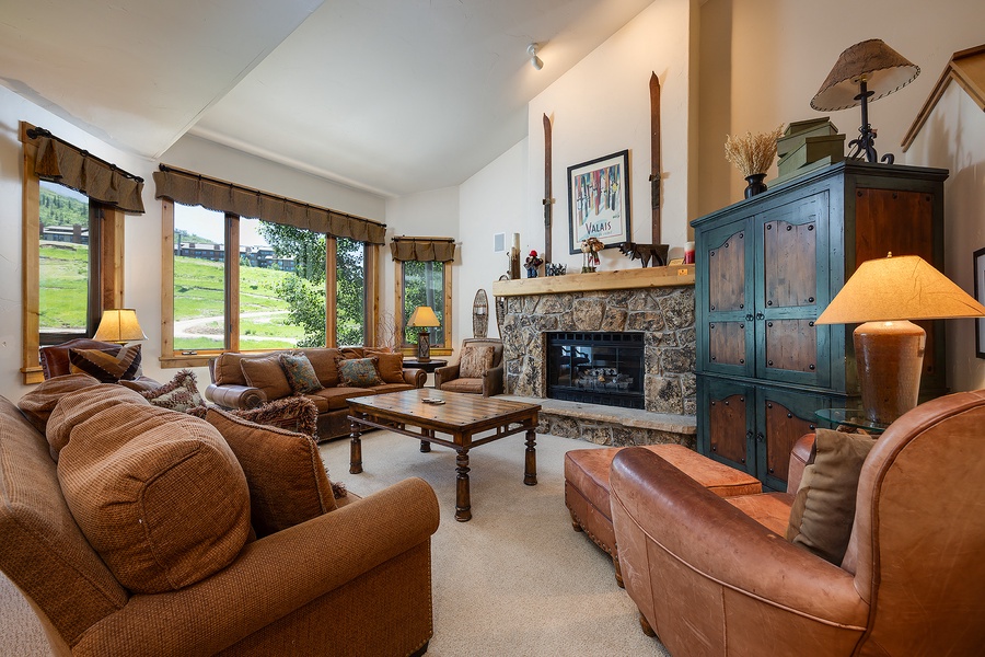 Curl up on plush sofas by the stone fireplace as natural light pours through tall windows, revealing views of rolling greens. Warm lamps and rustic touches create your perfect retreat.