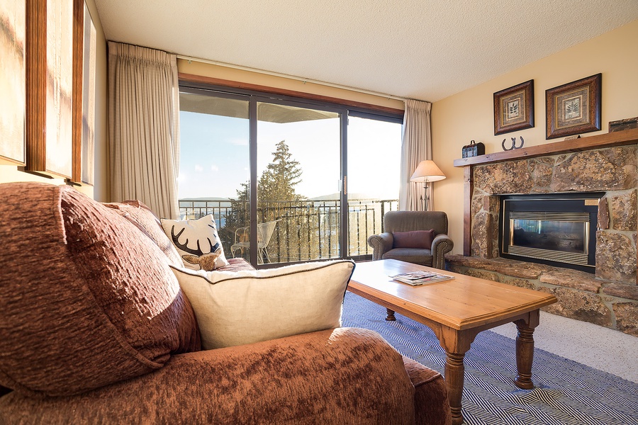 Curl up by your cozy stone fireplace after a day of adventure. Floor-to-ceiling windows invite natural light while plush seating and mountain charm create your perfect retreat.