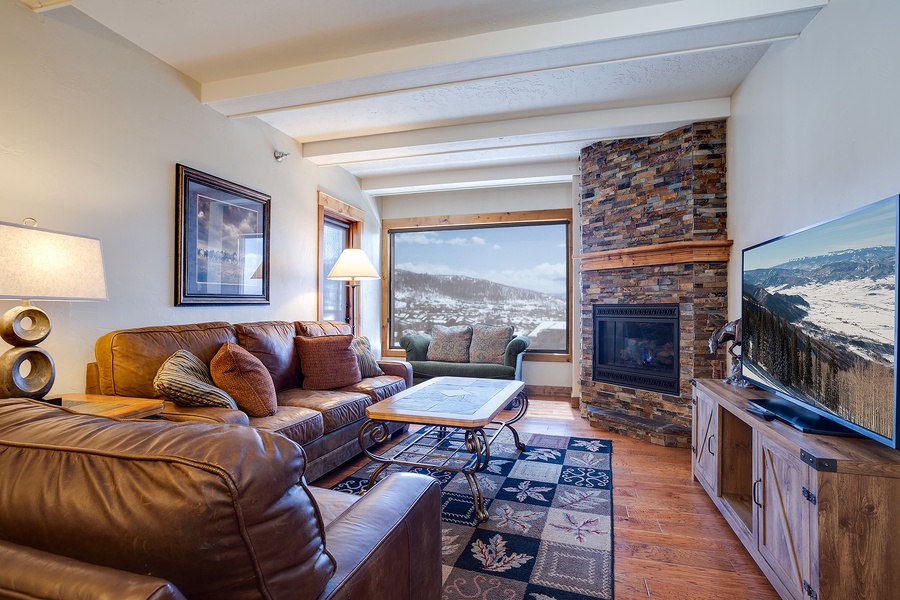 Sink into plush leather sofas by the stone fireplace and enjoy breathtaking mountain views through expansive windows—your perfect retreat after a day of adventure.