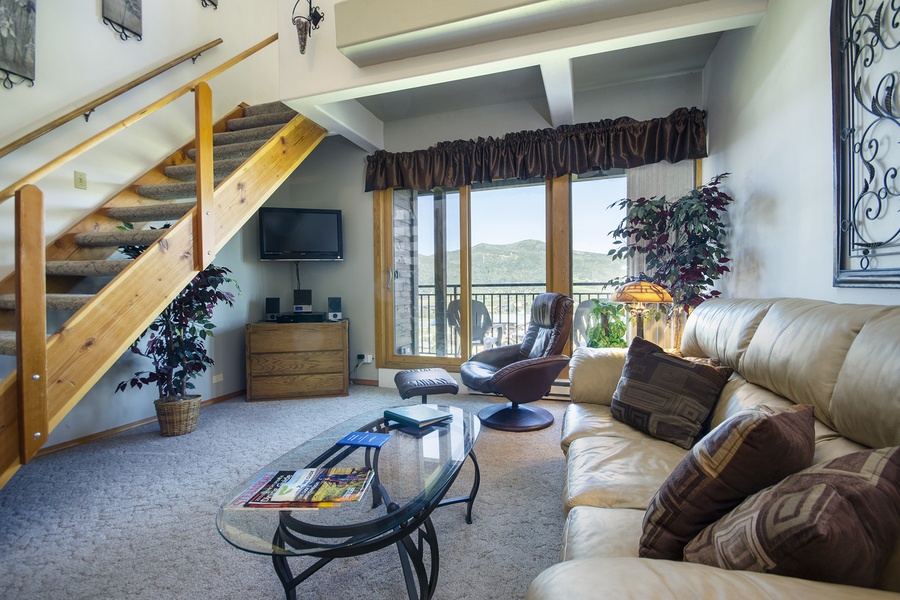 Sink into plush seating and soak up mountain vistas from your private balcony. This inviting loft-style living room blends cozy warmth with breathtaking natural beauty, perfect for your mountain escape.