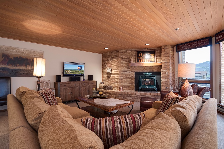 Sink into plush seating and unwind by the cozy fireplace in your spacious living room, where warm wood tones and mountain views create your perfect retreat.