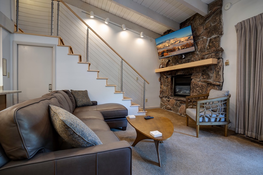 Unwind in your spacious living area with a stunning stone fireplace, vaulted ceilings, and cozy seating where you can relax and make yourself at home.