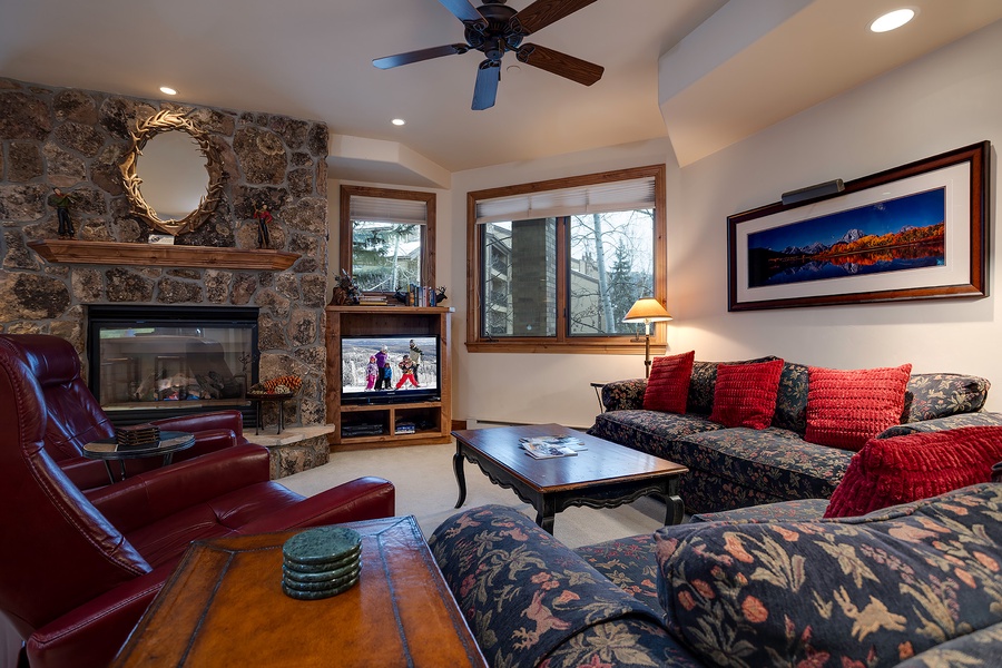 Settle into your cozy living room with a crackling stone fireplace, plush seating, and mountain artwork that captures the alpine spirit all around you.