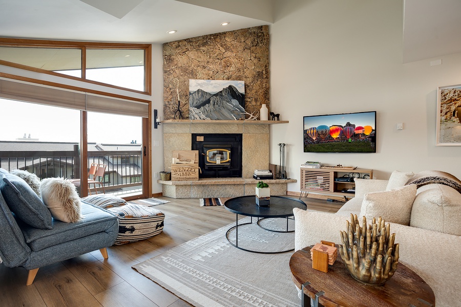 Sink into plush seating by your private stone fireplace, where mountain views frame cozy evenings and modern comforts create your perfect retreat.