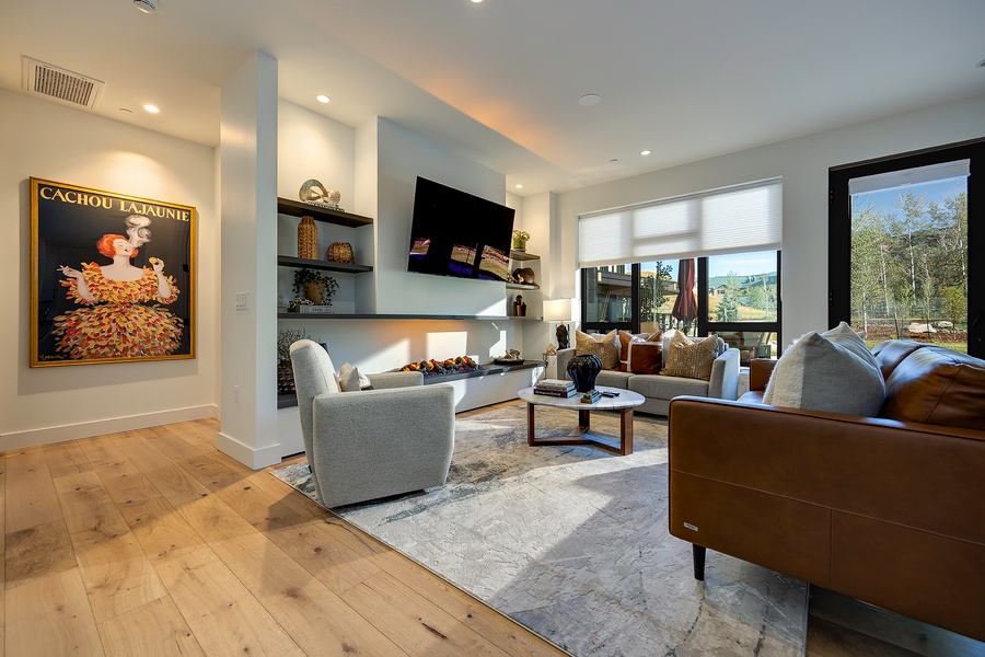 Unwind in your light-filled living room, where sleek built-ins and a cozy fireplace set the stage for relaxing evenings with mountain views just beyond the windows.