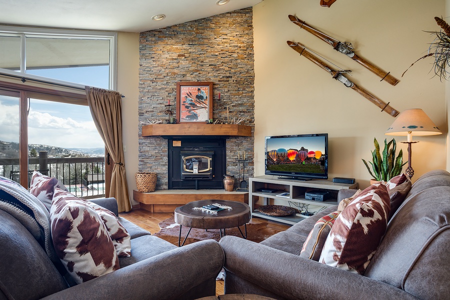 Cozy up by the stone fireplace in your living room, where mountain views frame a space designed for relaxation. Sink into plush seating after a day on the slopes.