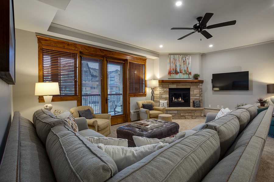Curl up in this cozy living room with plush sectional seating, a warm stone fireplace, and ample space for your group to relax together after a day of adventure.
