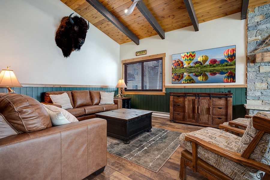 Sink into plush leather sofas beneath soaring wood-beam ceilings, where rustic charm meets colorful mountain décor. Your cozy retreat awaits, complete with unique character and inviting warmth.